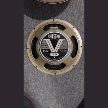 Kruhový reproduktor se zlatým kovovým rámem. Na středovém krytu je černobílý nápis CELESTION, velký symbol V a texty G12, 70-watt, TYPE a CELESTION I…