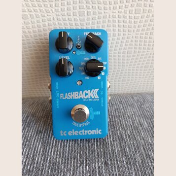 Modrý efekt pedál s nápisy FLASHBACK DELAY AND LOOPER a tc electronic. Na horní části jsou tři černé ovládací knoflíky, přepínač s označením MASH a n…