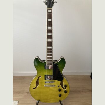 Polodupatá elektrická kytara s žlutozeleným přechodem barvy na těle a hnědým hmatníkem s blokovými vložkami. Nástroj má dva humbuckery, stříbrný most…