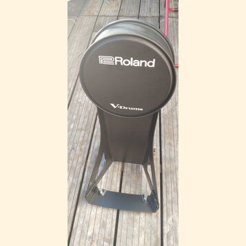 Černý elektronický bicí pad na stojanu. Na horní části je bílý nápis Roland a pod ním V-Drums. Povrch padu i stojanu je v dobrém stavu bez viditelnéh…