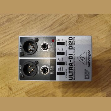 Stříbrná DI box s nápisy ULTRA-DI DI20 a behringer. Zařízení obsahuje dva vstupy typu jack a dva výstupy XLR, označené jako CH 1 IN / OUT a CH 2 IN /…