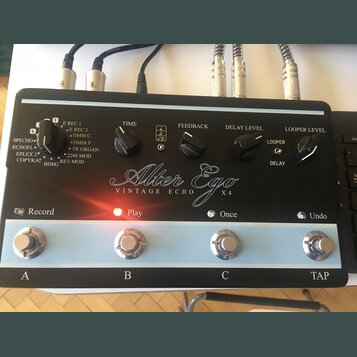 Černý efekt pedál s nápisem Alter Ego VINTAGE ECHO X4. Zařízení má v horní části pět otočných ovladačů s popisky TIME, FEEDBACK, DELAY LEVEL a LOOPER…