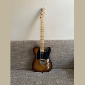 Elektrická kytara typu Telecaster s dřevem s výraznou žilnatostí a tmavě hnědým přechodem k okrajům. Nástroj má černý pickguard, jeden krkový snímač…