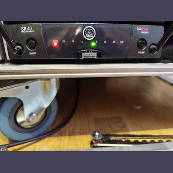 Detailní pohled na přední panel černého zařízení s nápisy SR 40 MULTI FREQUENCY, AKG a FLEXX PRO DIVERSITY. Na panelu jsou dvě černé ovládací knoflík…