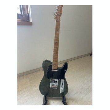 Elektrická kytara typu Telecaster s tmavě šedým trupem s viditnou strukturou dřeva a černým pickguardem. Hmatník a hlava jsou vyrobeny ze světlého dř…