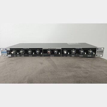 Stříbrný rackový procesor s nápisem RHSOUND vlevo a označením CX223 STEREO 2 WAY/MONO 3 WAY CROSSOVER vpravo. Přední panel obsahuje tři sekce: CHANNE…