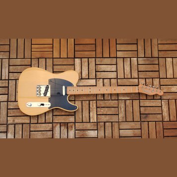 Elektrická kytara s přírodním dřevěným povrchem těla a hmatníkem. Na hlavě je viditelné logo Fender. Nástroj má černý pickguard a dva snímače. Povrch…