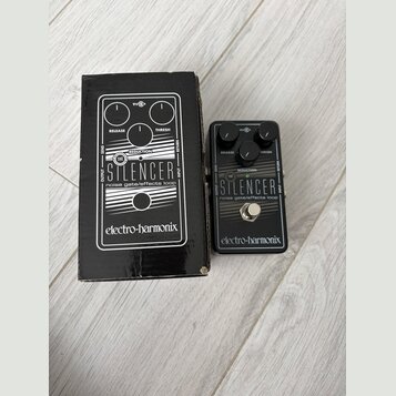 Černý efekt pedál s nápisy THE STILENCER a noise gate/effects loop, značka electro-harmonix. Zařízení má dva ovládací knoflíky s popisky RELEASE a TH…