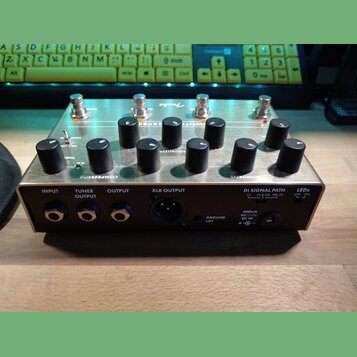 Kovový efekt pedál stříbrné barvy s černými oválnými ovladači a čtyřmi stomečovými spínači. Na horní straně jsou nápisy COMPRESSOR, EQUALIZER a OVERD…