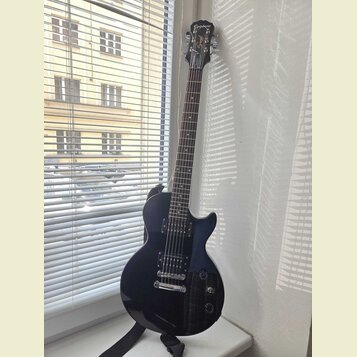 Tmavě modrá elektrická kytara typu Les Paul s černým hmatníkem a stříbrným hardwarem. Na hlavě je bílý nápis Epiphone a logo Spiral. Kytara má dva hu…