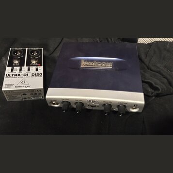 Na fotografii jsou dvě zařízení. Vlevo je bílá DI box s nápisy „behringer“, „ULTRA-DI DI20“ a „PROFESSIONAL ACTIVE 2-CH DI-BOX/SPLITTER“. Vpravo je s…