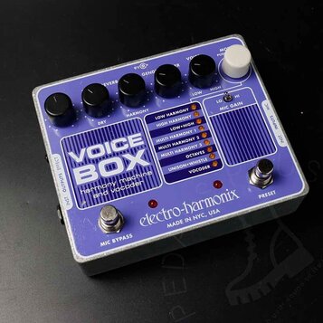 Fialový efekt pedál s bílým nápisem VOICE BOX a podtitulem harmony machine and vocoder. Na spodní části je uveden výrobce electro-harmonix a nápis MA…