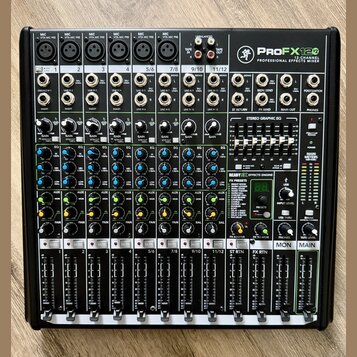 Černý 12kanálový mixážní pult s nápisem ProFX12 PROFESSIONAL EFFECTS MIXER. Zařízení obsahuje řadu vstupních kanálů s ovládacími knofíky, posuvníky a…