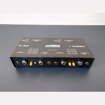 Černá DI-box s nápisy DI-BOX, 2 CHANNELS a logem CORDIAL SOUND & AUDIO EQUIPMENT. Na horní straně je označení CES02 a přepínače pro GND (OFF/ON), BAL…