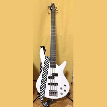 Bílá elektrická basová kytara s tmavým hmatníkem a čtyřmi strunami. Na hlavě nástroje je nápis "Epiphone". Kytara má připevněný popruh s černobílým š…