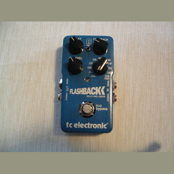 Modrý efekt pedál s nápisy FLASHBACK DELAY AND LOOPER a tc electronic. Zařízení má čtyři černé ovládací knoflíky s popisky LEVEL, DYN, LOFI, TAPE, AN…