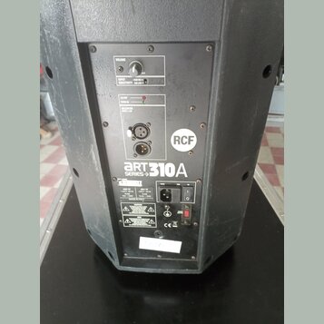 Zadní panel černého aktivního reproduktoru značky RCF. Na panelu je nápis ART 310A SERIES, ovládací prvek VOLUME a přepínač INPUT SENSITIVITY s hodno…