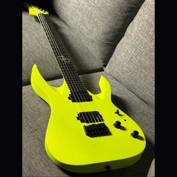 Neonově žlutá elektrická kytara s matným povrchem a výrazně vyčnívajícími rohy korpusu. Nástroj má dva černé humbuckery, černý most a dva ovládací kn…