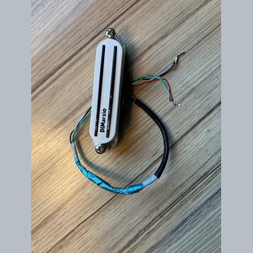 Bílý humbucker s dvěma černými polosnovými kryty snímačů. Na spodní části je svisle napsáno logo DiMarzio. Snímač má připojovací kabely v různých bar…