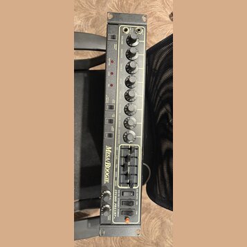 Kytarový předzesilovač v rackovém provedení s černým šasi a béžovým předním panelem. Na panelu je nápis Mesa/Boogie a STUDIO PREAMP TM. Zařízení obsa…