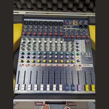 Modrý mixážní pult v hliníkovém kufru s pěnovou výplní. Na přístroji jsou vidět nápisy "exicon" a "Soundcraft EFX8". Zařízení obsahuje osm vstupních…