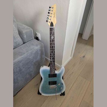 Elektrická kytara s modrým přechodovým povrchem těla a hnědým hmatníkem. Na hlavě je viditelné logo Fender. Hmatník obsahuje bílé dekorativní vložky…