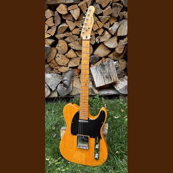 Elektrická kytara s přírodním dřevěným povrchem těla a hmatníku. Na hlavě je viditelné logo Fender. Kytara má černý pickguard a dva snímače. Povrch t…