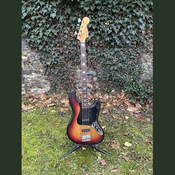 Elektrická basová kytara s korpusem v červeno-žlutém sunburst provedení a černým pickguardem. Na hlavě hmatníku je vidět nápis „Westminster“. Nástroj…