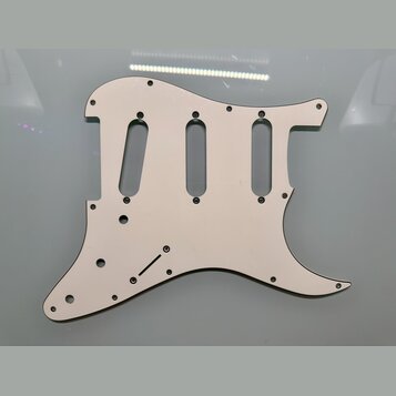 Bíle plastykový pickguard pro elektrickou kytaru s výřezy pro tři snímače. Povrch je hladký a čistý, bez viditelných značek, log nebo nápisů. Kolem o…