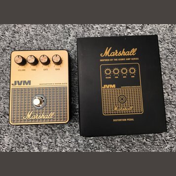 Na fotografii je efekt pedál a jeho originální černá krabice. Pedál má zlatý povrch s nápisy JVM, DISTORTION & NOISE GATE a Marshall. Obsahuje čtyři…