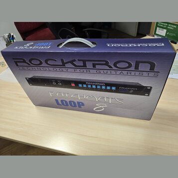 Kartonová krabice s produktem RockTron. Na povrchu je velký nápis ROCKTRON TECHNOLOGY FOR GUITARISTS a níže označení PATCHMATE LOOP 8. Uprostřed je v…