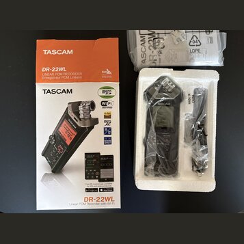 Fotografie zobrazuje digitální záznamové zařízení TASCAM DR-22WL v původním balení. Na oranžovo-bílé krabici jsou nápisy TASCAM, DR-22WL LINEAR PCM R…