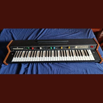 Černý elektronický klávesový nástroj s dřevěnými bočními panely. Na levé straně ovládacího panelu je bílý nápis VERMONA a vpravo nápis PIANO. Nástroj…