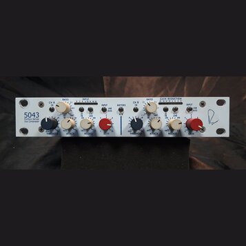 Bílý rackový kompresor s nápisem 5043 Portico Series Duo Compressor. Zařízení má dvě identické sekce ovládání (CH A a CH B) s bílými a červenými otoč…