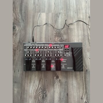 Šedý multifunkční efektový pedál s nápisem BOSS ME-80 Guitar Multiple Effects. Zařízení má horní panel s řadou ovládacích knoflíků, přepínačů a červe…