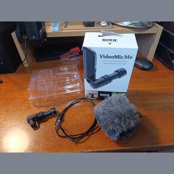 Na fotografii je mikrofon s příslušenstvím a originální krabicí. Na bílé krabici jsou nápisy RØDE MICROPHONES, VideoMic Me™, Directional microphone f…