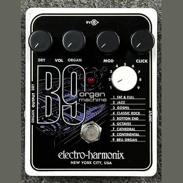Kytarový efekt v bílém rámečku s černým povrchem. Na zařízení je nápis B9 organ machine a značka electro-harmonix NEW YORK CITY, USA. Obsahuje čtyři…