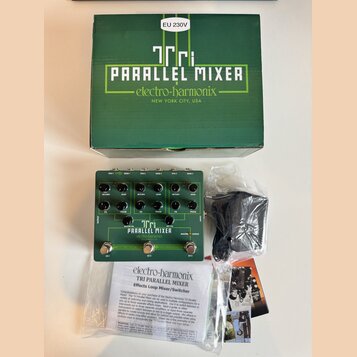 Na fotografii je zelený efektový pedál Electro-Harmonix Tri Parallel Mixer v doprovodu originální krabice, napájecího adaptéru v plastovém sáčku a pr…