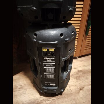 Černý pasivní reproduktor v plastovém krytu. Na zadním panelu je nápis SAMSON aura a text 400 WATT PASSIVE SPEAKER CABINET. Jsou zde vidět konektory…
