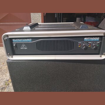 Černý výkonový zesilovač v bílém rámu s madly na horní straně. Na předním panelu jsou nápisy EUROPOWER PROFESSIONAL SOUND REINFORCEMENT SERIES, EP400…