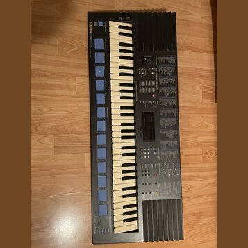 Černý digitální klavír s bílými a černými klávesami. V levém horním rohu je nápis YAMAHA a v levém dolním rohu nápis MUSIC-STATION. Nástroj obsahuje…