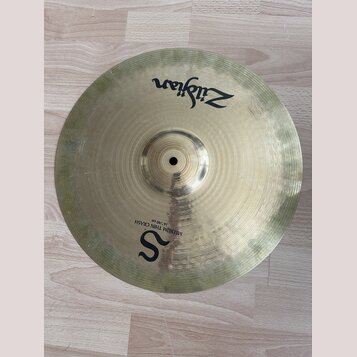 Kruhová mosazná činely s viditelným broušením povrchu. Na horní části je černý nápis Zildjian a ve spodní části velké písmeno S s dopisem MEDIUM THIN…