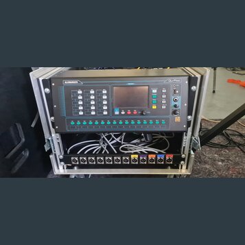 Digitální mixážní pult Allen&Heath Qu-Pac v černém provedení, umístěný v hliníkovém transportním case. Na předním panelu jsou viditelná tlačítka, pos…
