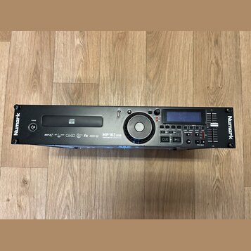 Černý rackový MP3 přehrávač s nápisy Numark na levém a pravém okraji. Na předním panelu je uvedený model MP 103 USB a nápis PROFESSIONAL MP3 MEDIA PL…
