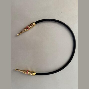 Černý instrumentální kabel s pozlacenými konektory typu 6,35 mm jack. Na červených kroužcích u obou konektorů je bílý nápis MONSTER. Na izolaci kabel…