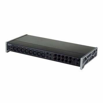 Černý rackový audio přístroj s kovovými úchyty po stranách. Na zadním panelu je vlevo nápis TASCAM a pod ním model CC-16SV. Zařízení obsahuje řadu ko…