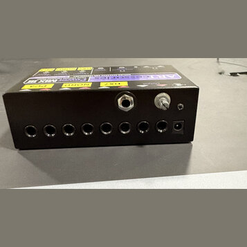 Černý obdélníkový box s řadou vstupních konektorů na přední straně. Na horní části jsou vidět nápisy „ARTcessories“, „Power MIX III“ a označení model…