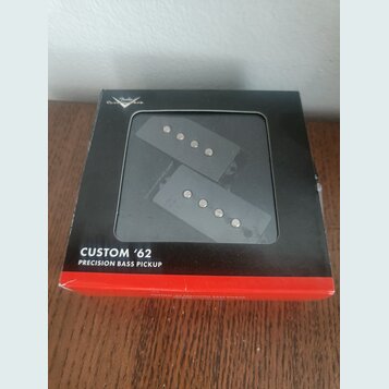 Černá krabička s červeným spodním okrajem obsahuje dva snímače pro basovou kytaru. Na přední straně krabičky je bílý nápis CUSTOM '62 PRECISION BASS…
