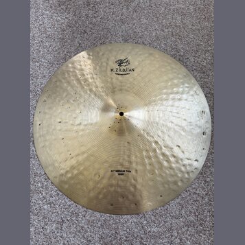 Zlatý kovový činel s viditelným kovánívým povrchem. Na horní části je nápis K. ZILDJIAN a pod ním CONSTANTINOPLE spolu s logem v arabském písmu. V do…