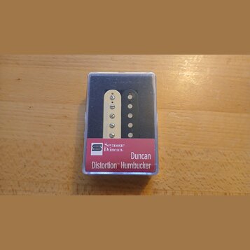 V průhledném plastovém obalu jsou dva humbuckery, jeden v krémové a druhý v černé barvě. Na červeném štítku je uveden nápis Seymour Duncan, Duncan Di…